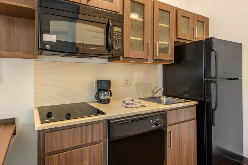 Full-size kitchen with refrigerator, stove top and